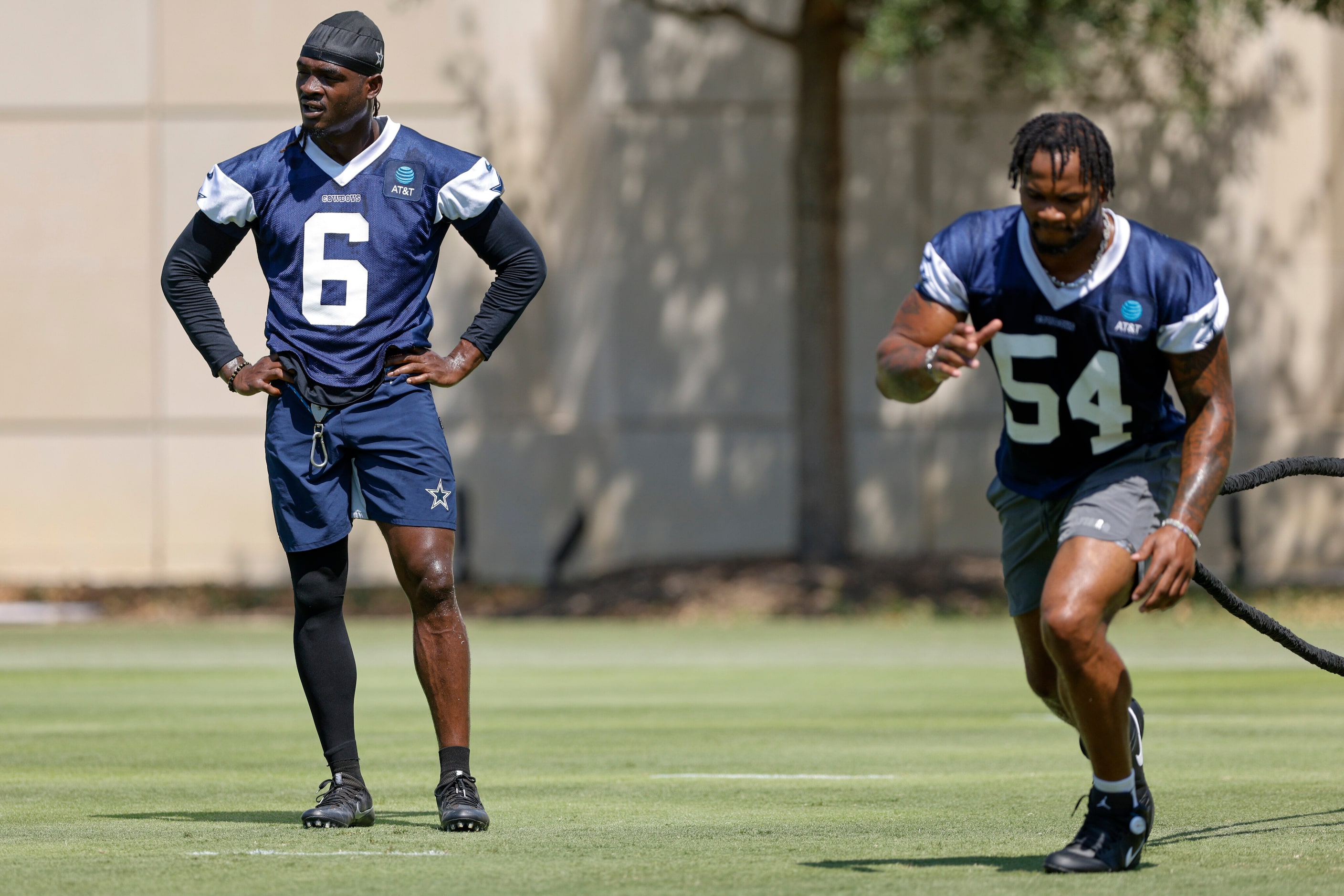 Dallas Cowboys safety Donovan Wilson (6) watches practice as defensive end Sam Williams (54)...