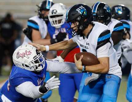 Rock Hill High School quarterback Kevin Sperry Jr. (9) stiff arms Allen High School...