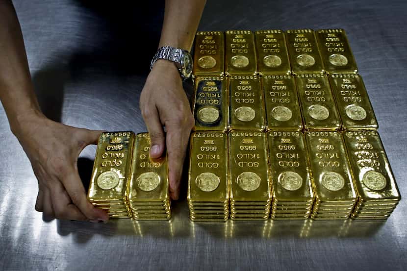 FILE - In this Tuesday Oct. 9, 2012 file photo, a technician prepares 1 Kg  gold bars of...