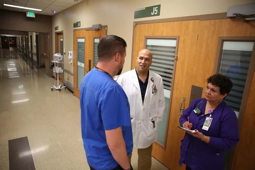 A purple light is illuminated to show that a room is ready for the next patient as nurse...