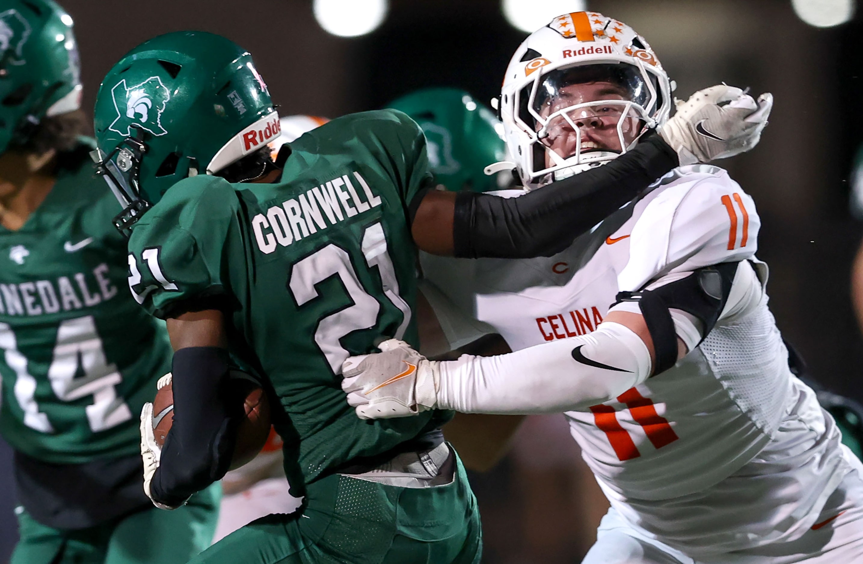 Kenneddale running back Josh Cornwell (21) is brought down for a loss by Celina defensive...