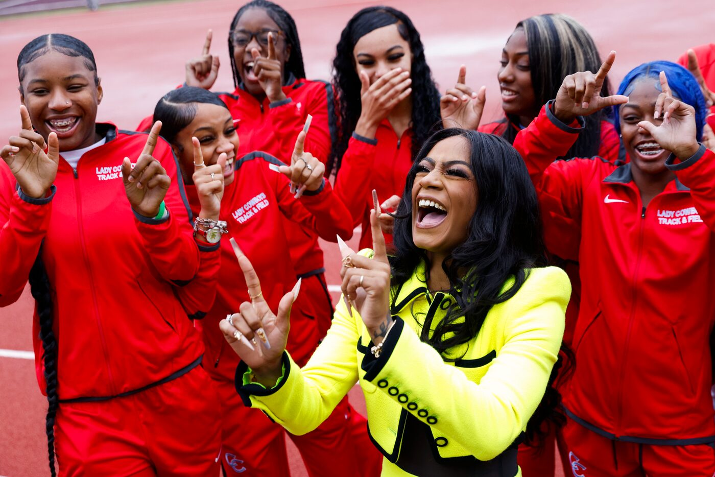 100 meters world champion Sha'Carri Richardson, (center), cheers with David W. Carter High...