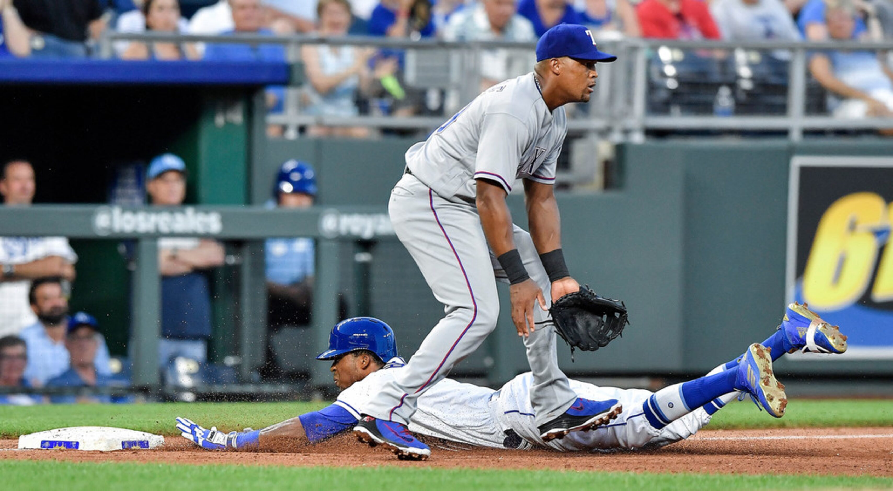 Kansas City Royals' Rosell Herrera slides into third on an RBI triple past Texas Rangers...