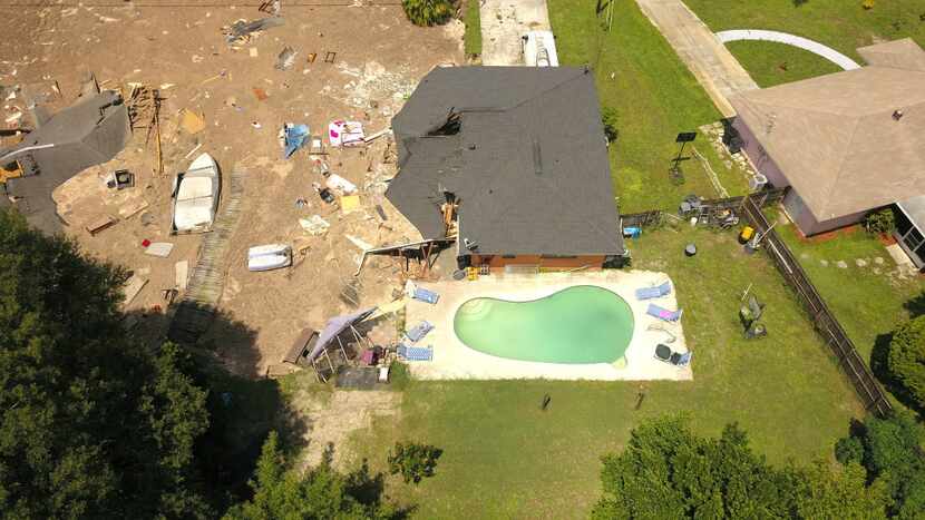 Debris is strewn about after a sinkhole damaged two homes in Land O' Lakes, Fla. (Luis...