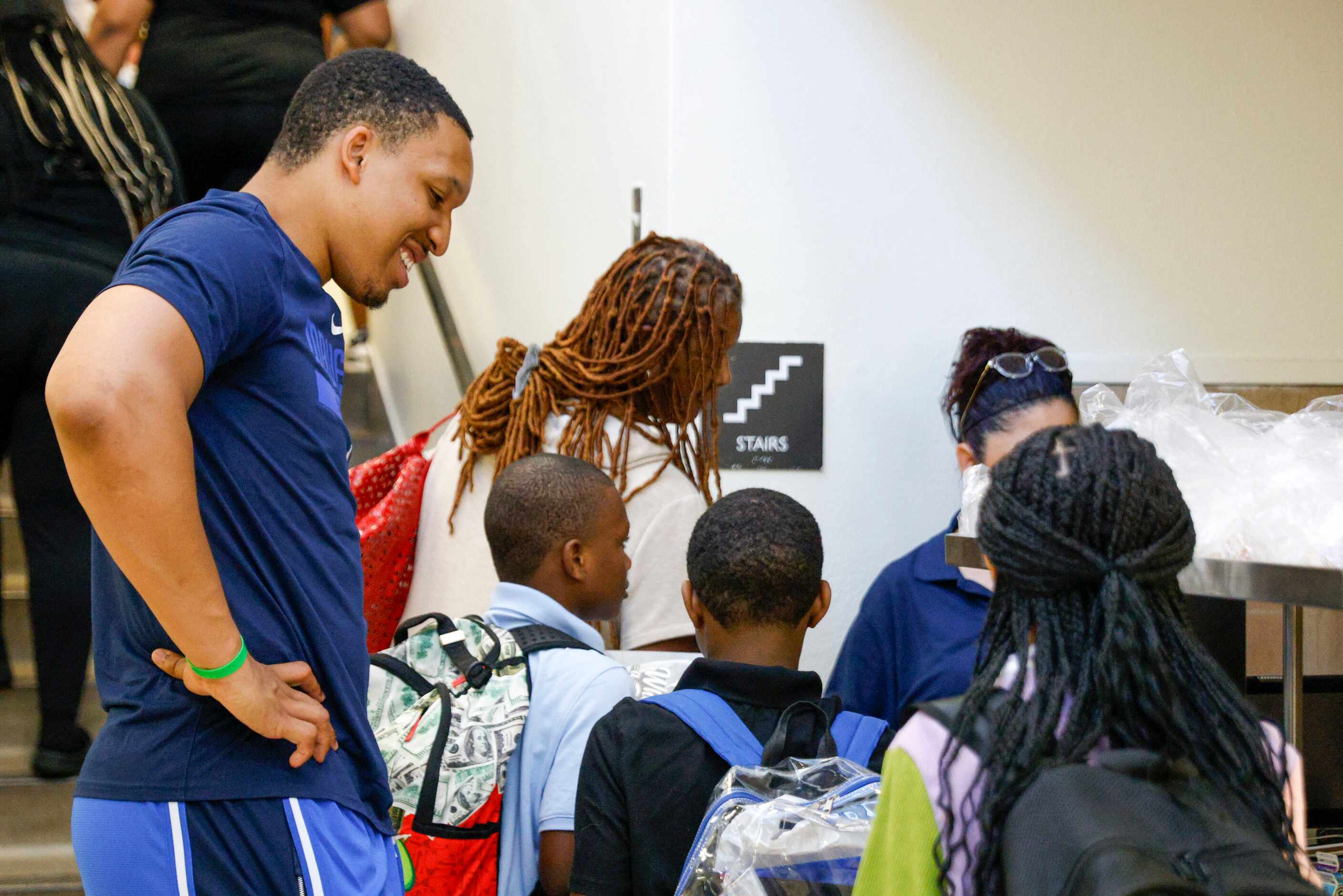Dallas Mavericks forward Grant Williams (left) helps pass out breakfast to students during...