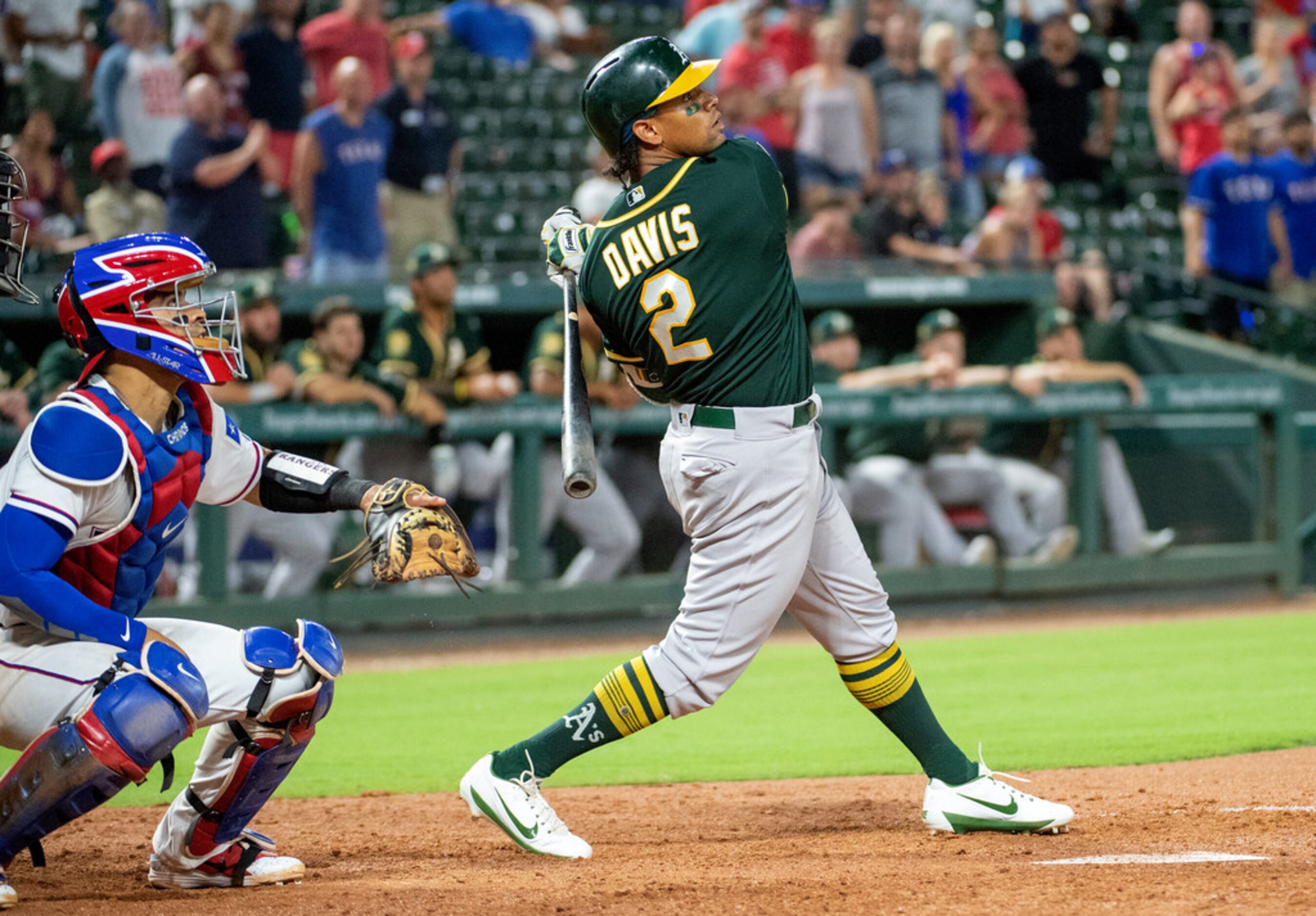 Oakland Athletics' Khris Davis and Texas Rangers catcher Robinson Chirinos watch the flight...