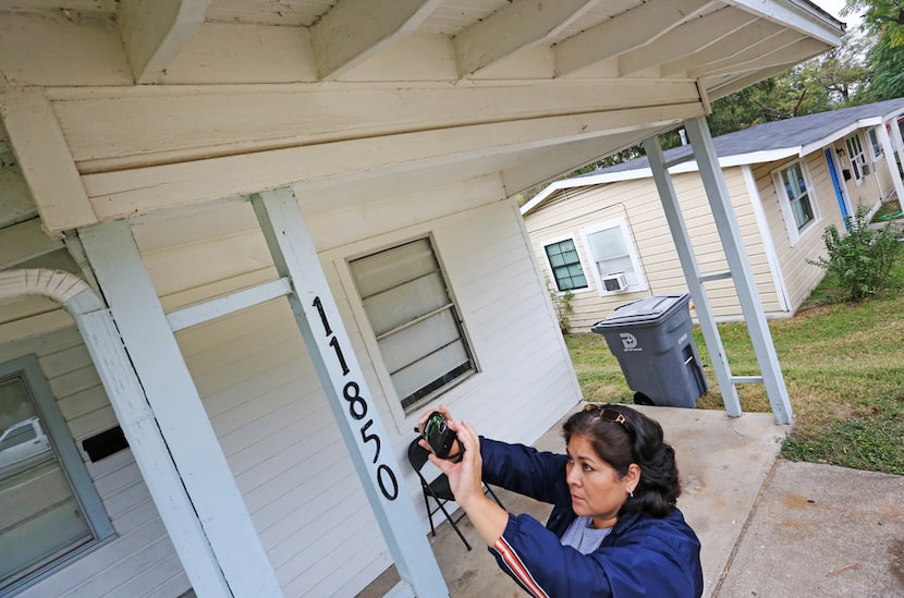 City of Dallas code inspector Diana Conde takes a photo of a repair that was done to the...