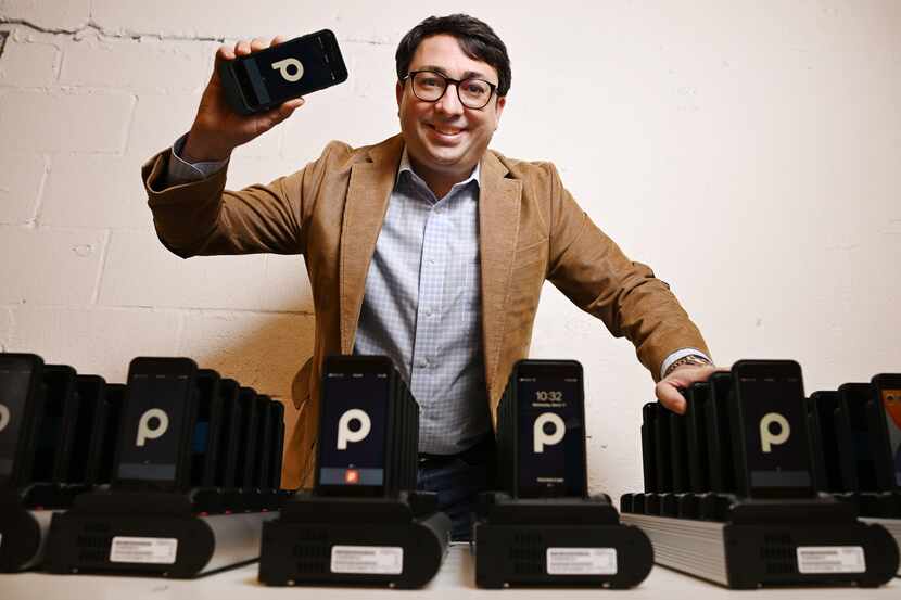 George Baker, founder, chairman and CEO of ParkHub, holds a point-of-sale device at the...