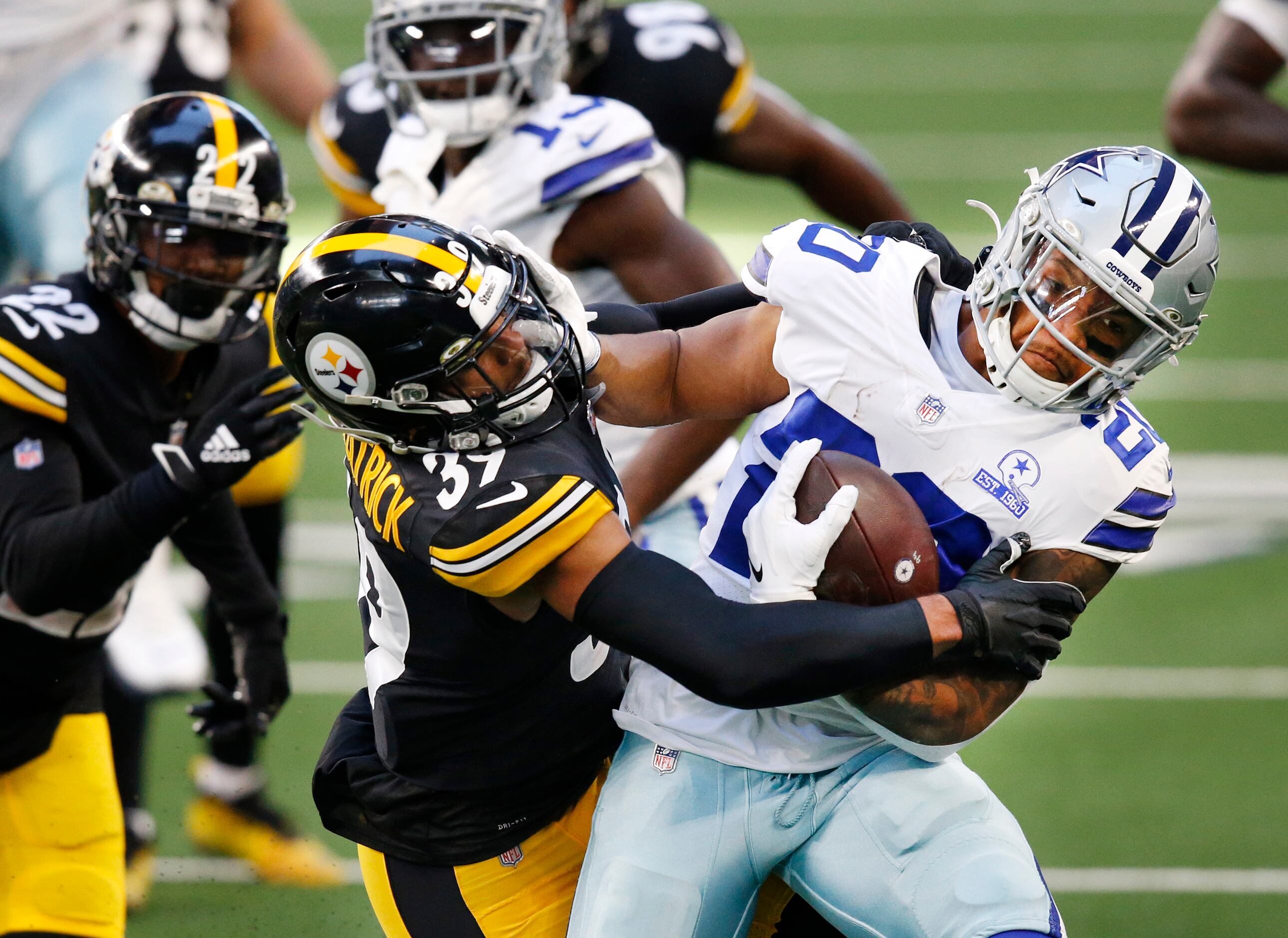Dallas Cowboys running back Tony Pollard (20) gives a stiff arm to Pittsburgh Steelers free...