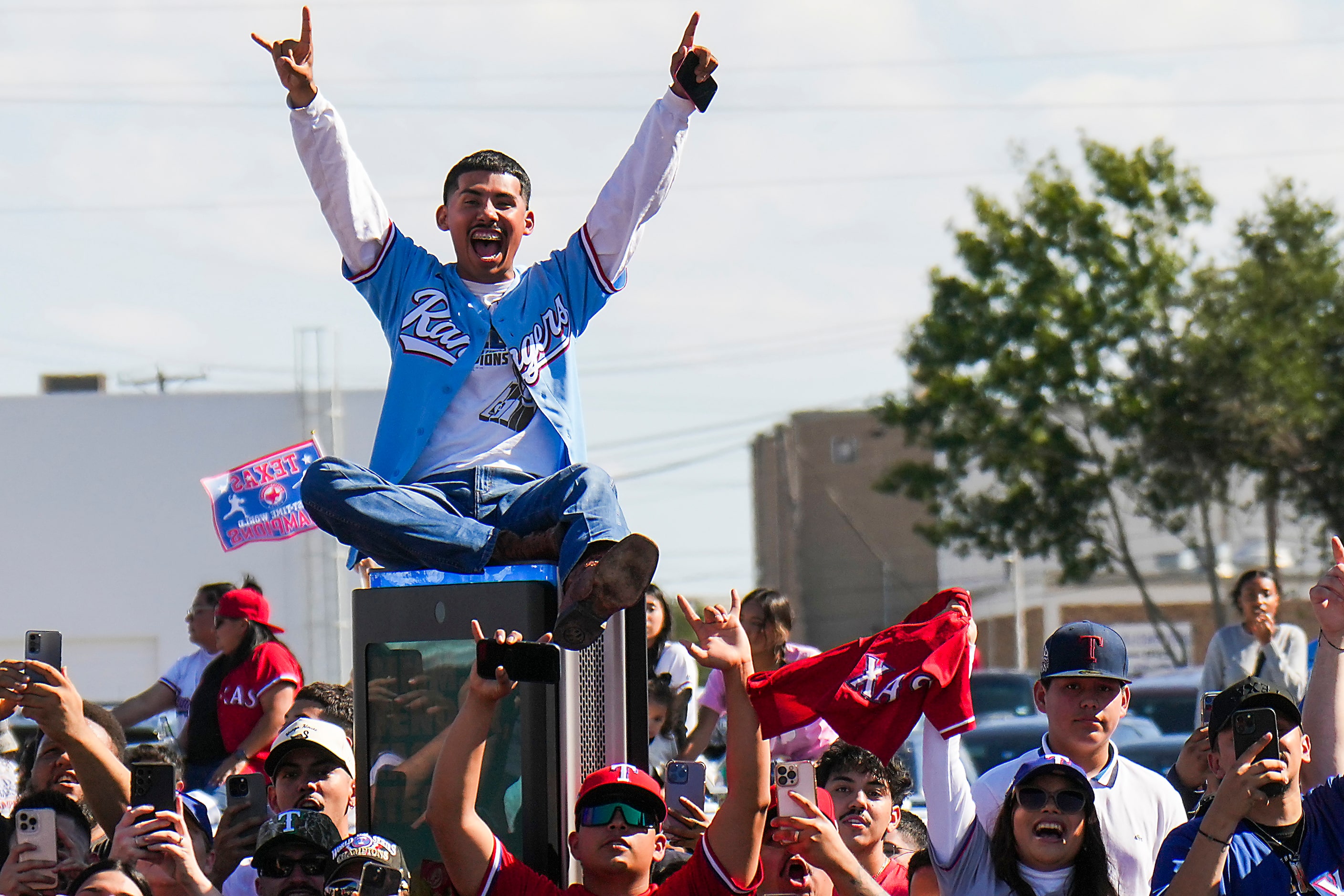 Fans cheer along the parade route during the Texas Rangers World Series victory parade,...