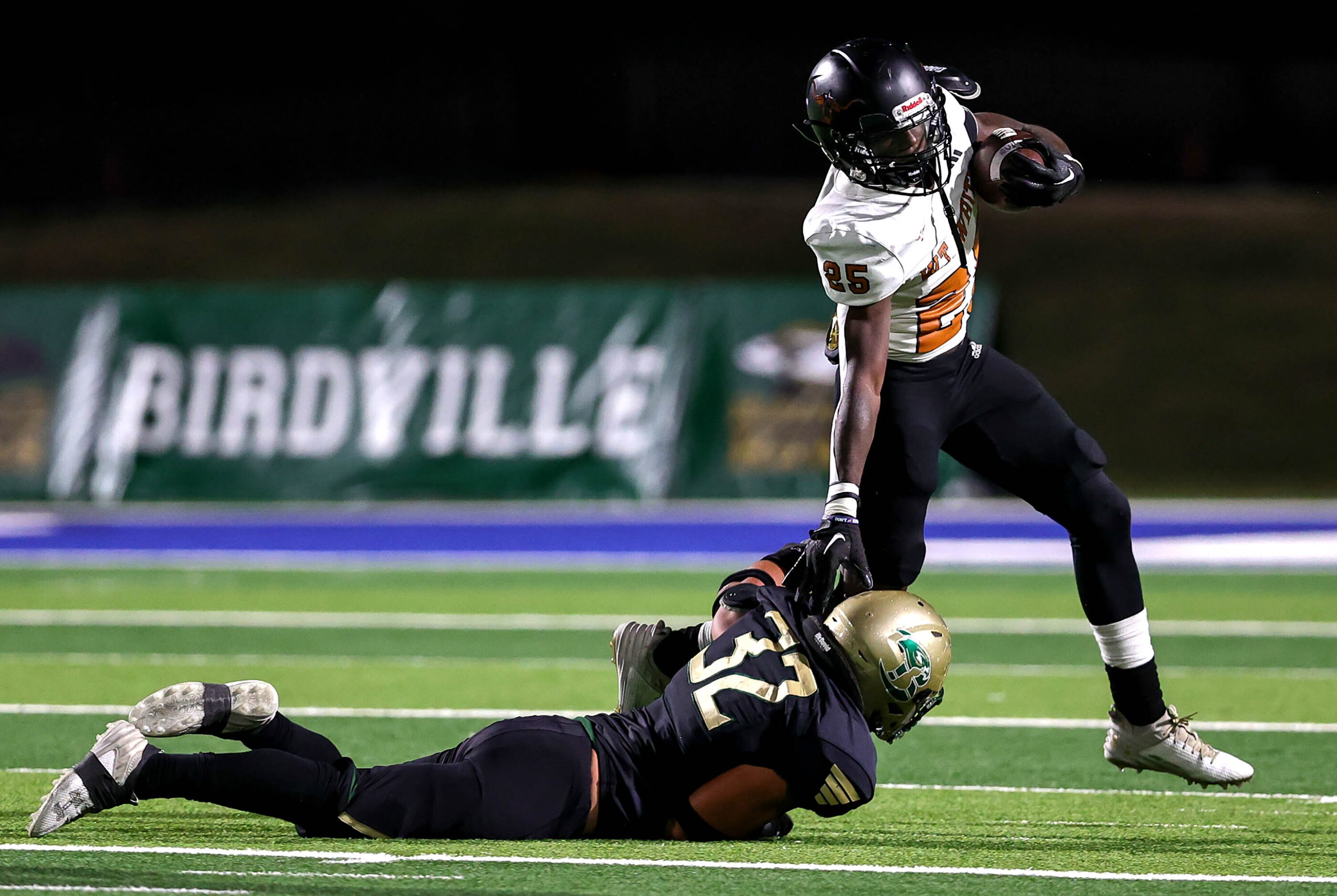 W.T. White running back Ben Ebeke (25) tries to break loose from Birdville linebacker Jayden...