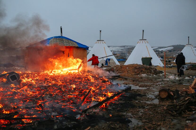 Campers set structures on fire in preparation of the Army Corp's 2pm deadline to leave the...