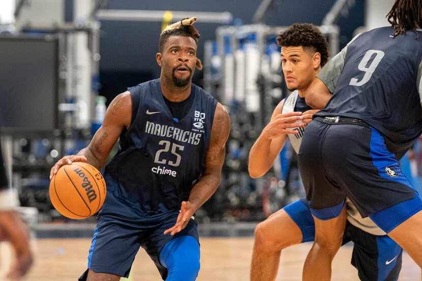 Dallas Mavericks guard Reggie Bullock (25) drives the lane as guard Josh Green tries to...