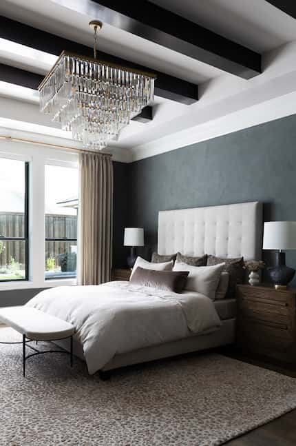 Bedroom with crystal chandelier and gray accent wall, with animal print rug