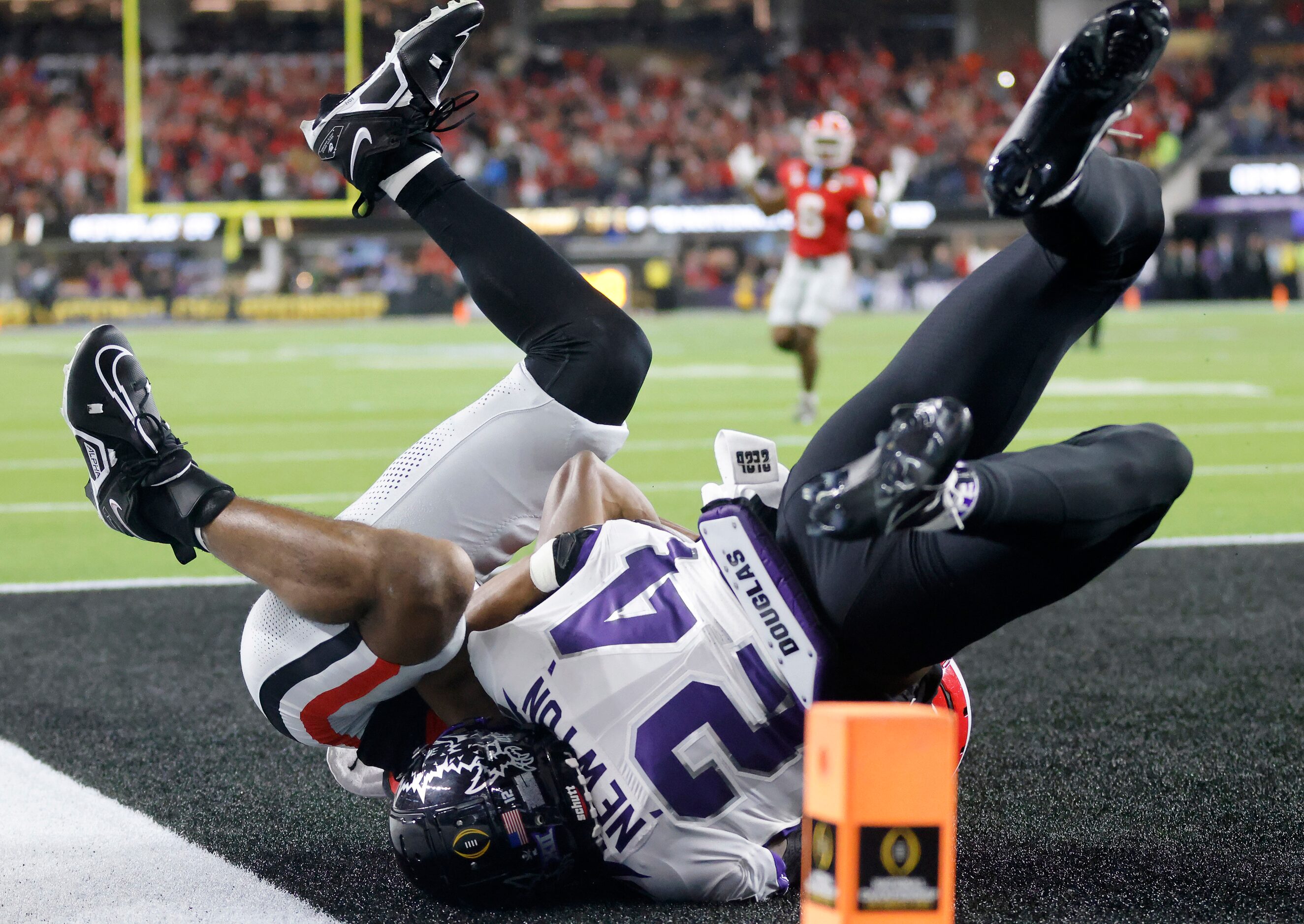 Georgia Bulldogs wide receiver Adonai Mitchell (5) wrestles with TCU Horned Frogs cornerback...