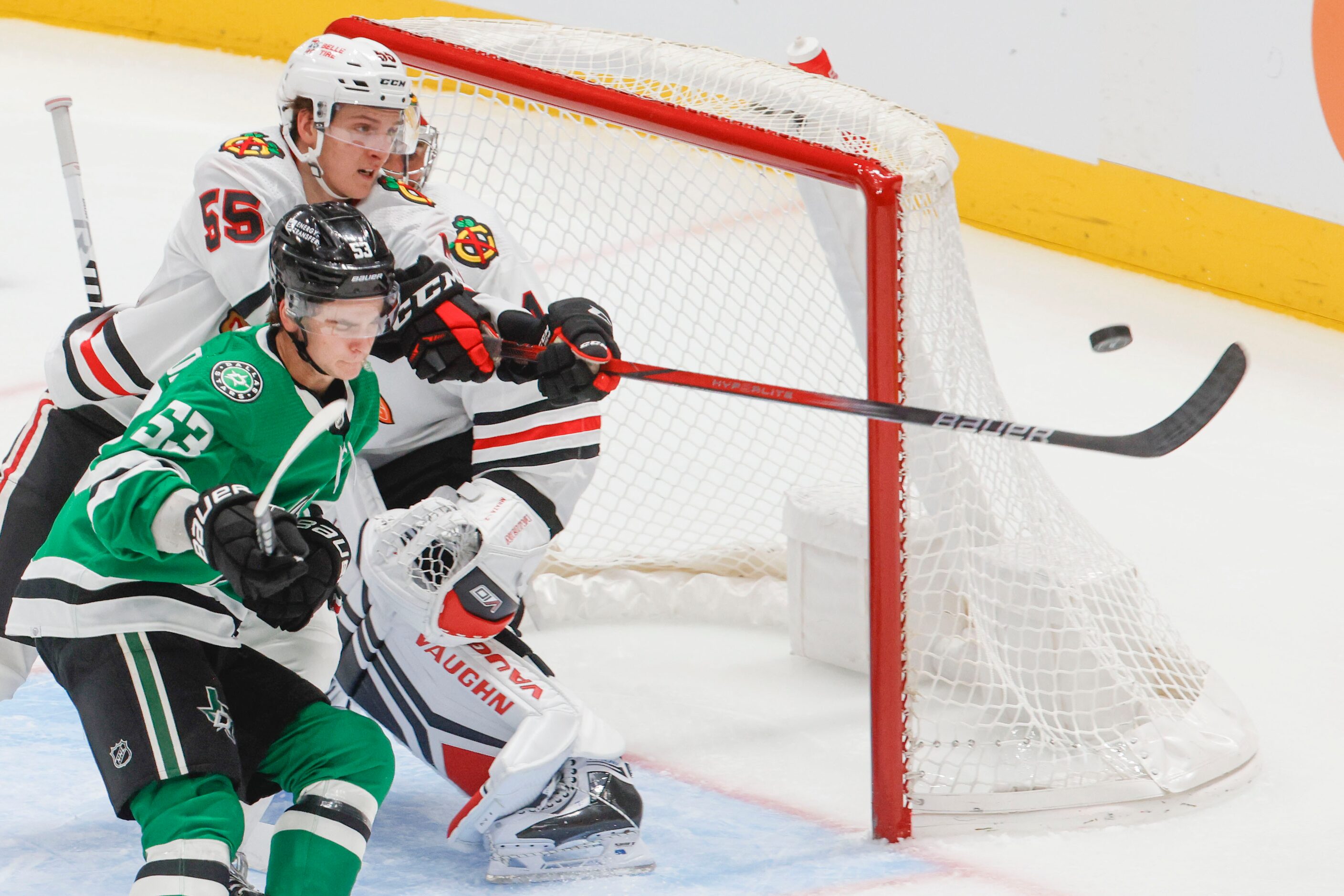 Chicago Blackhawks defenseman Kevin Korchinski (55) reaches to save a shot past Dallas Stars...