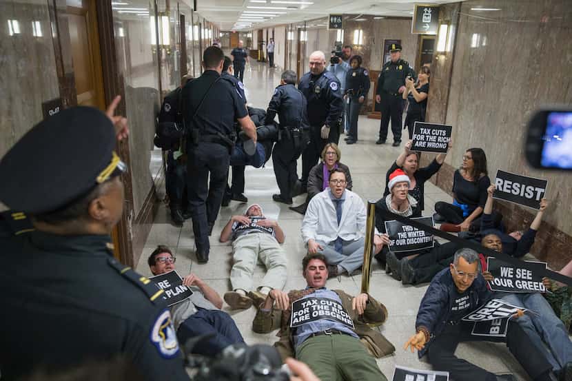 Protesters demonstrate Nov. 28 near the full Senate budget committee markup of the tax...