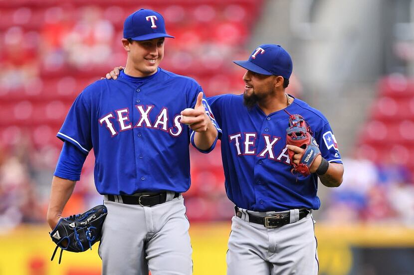 CINCINNATI, OH - AUGUST 23:  Pitcher Derek Holland #45 of the Texas Rangers gives the thumbs...