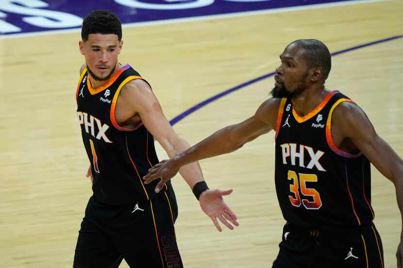 Phoenix Suns guard Devin Booker (1) and forward Kevin Durant (35) celebrate a basket against...