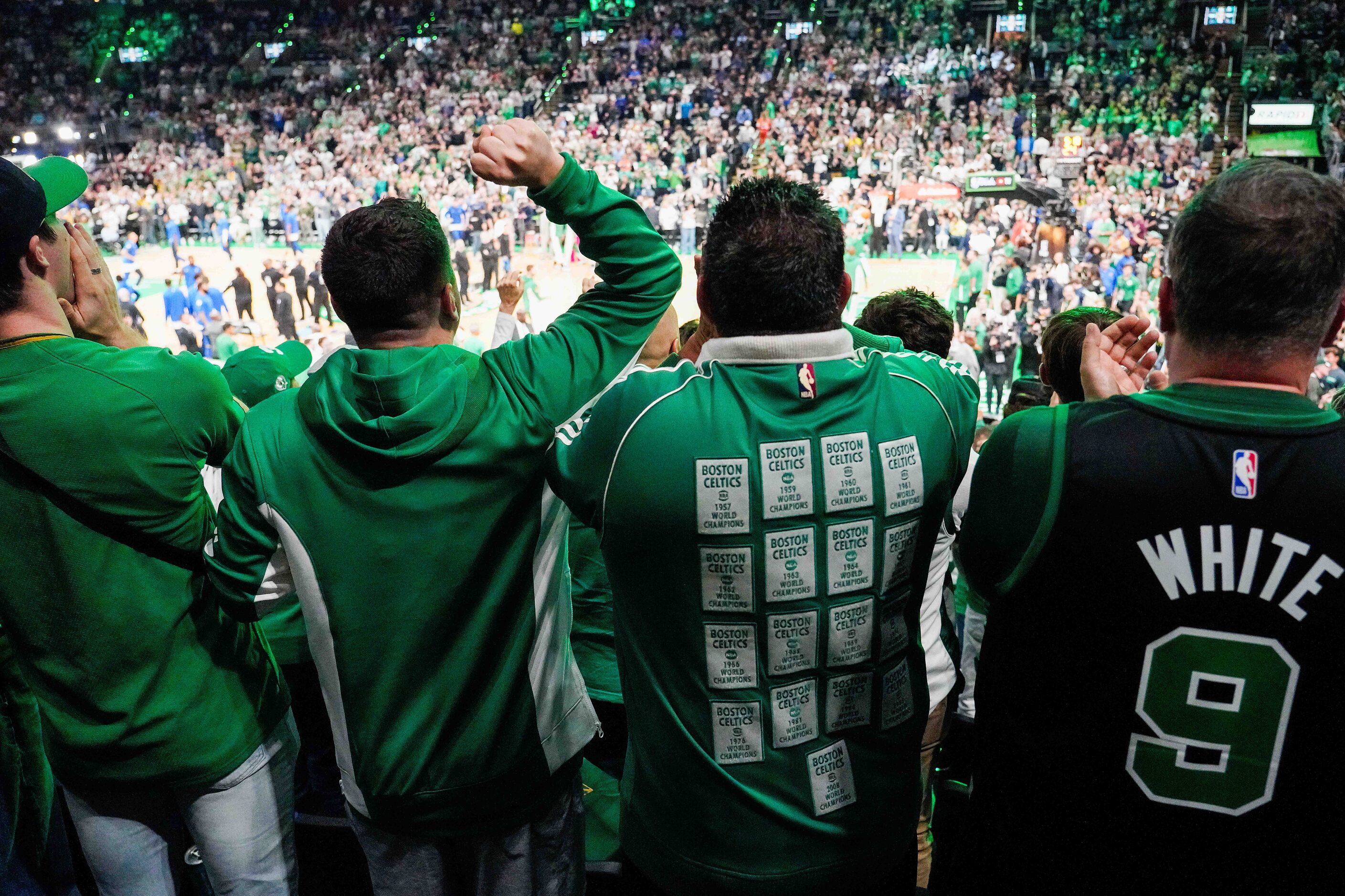 Boston Celtics fans cheer as center Kristaps Porzingis take the court to warm up before in...