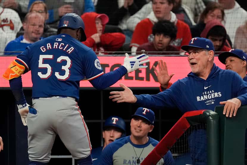 Texas Rangers' Adolis García (53) is greeted by Texas Rangers manager Bruce Bochy, right, at...