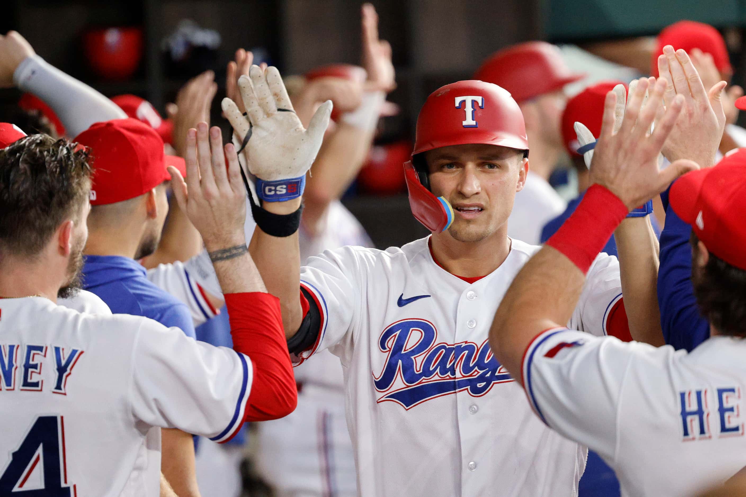 Texas Rangers shortstop Corey Seager (5), center, gets a high-five from his teammate after...