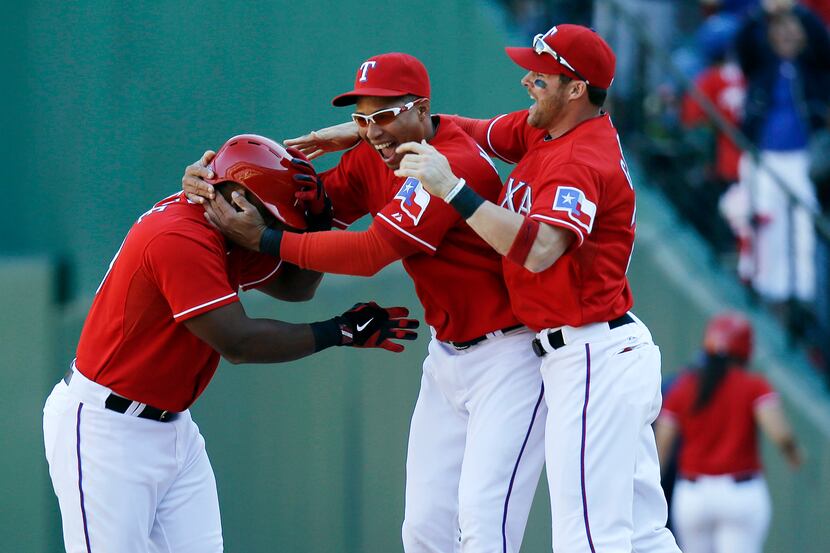 Texas Rangers' Adrian Beltre, left, is grabbed by Leonys Martin, center, and Craig Gentry...