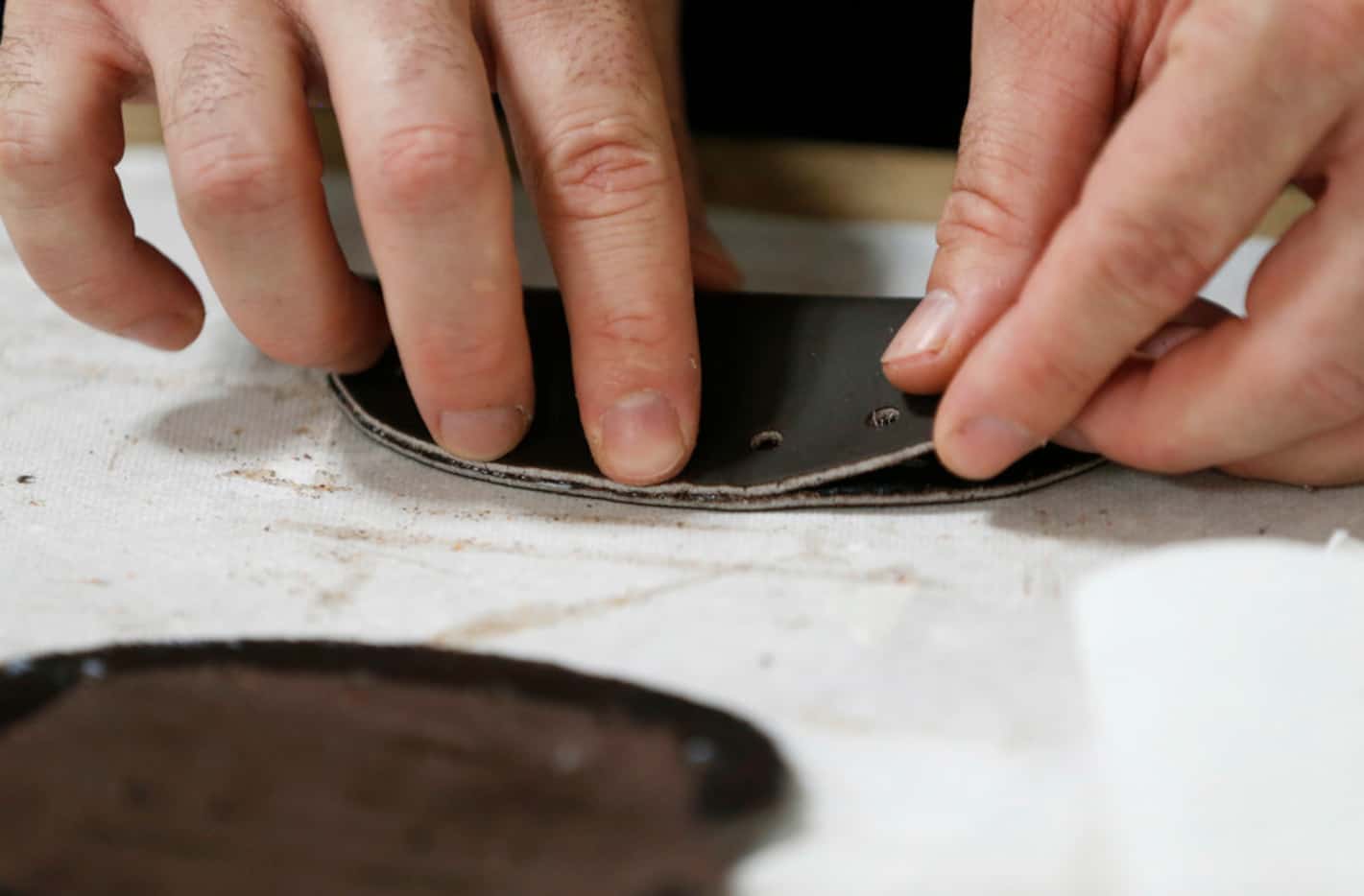 Kevin Ralls works on gluing pieces together before making the web area of a baseball glove...