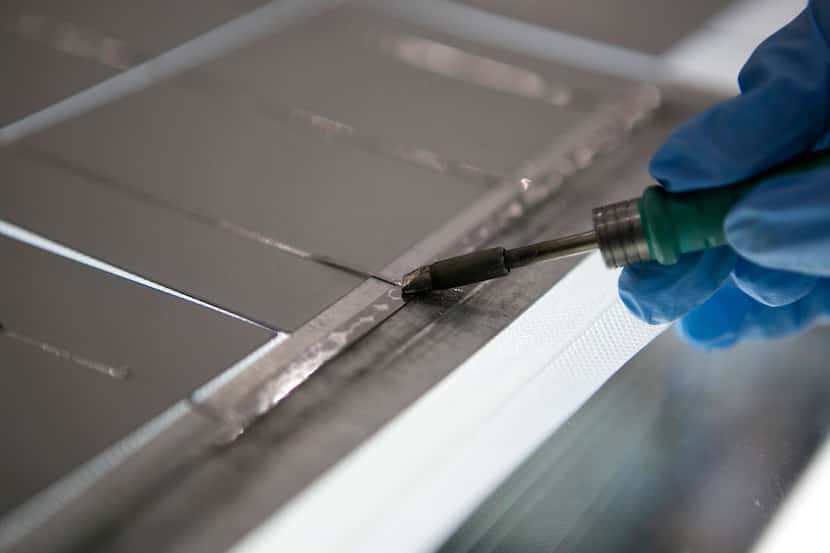 An employee solders photovoltaic panels at a Solartec SA renewable energy assembly plant in...
