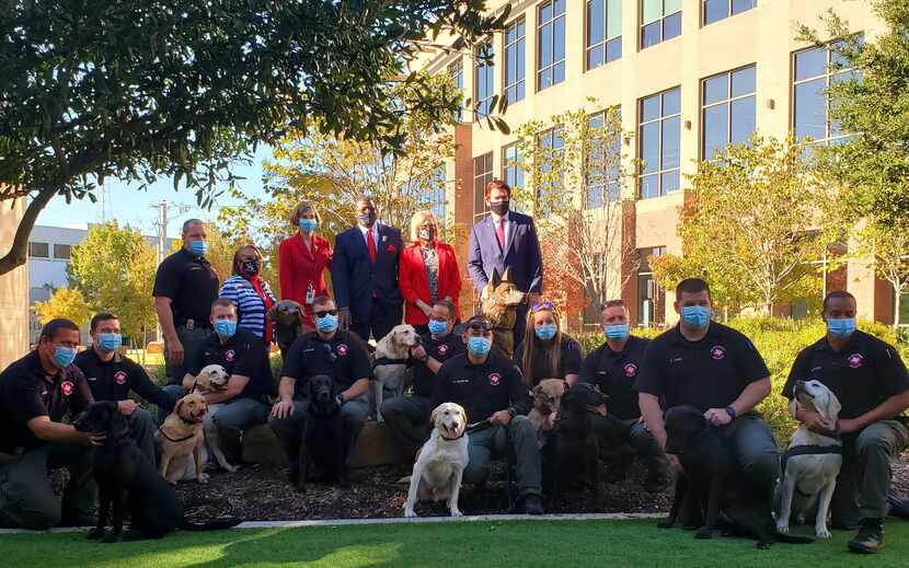 Arlington City Council members along with the city's K9 units pose around the new statue...
