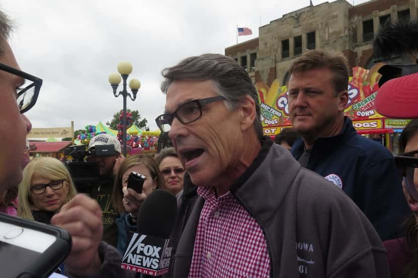  Former Texas Gov. Rick Perry talks with reporters as he tours the Iowa State Fair on...