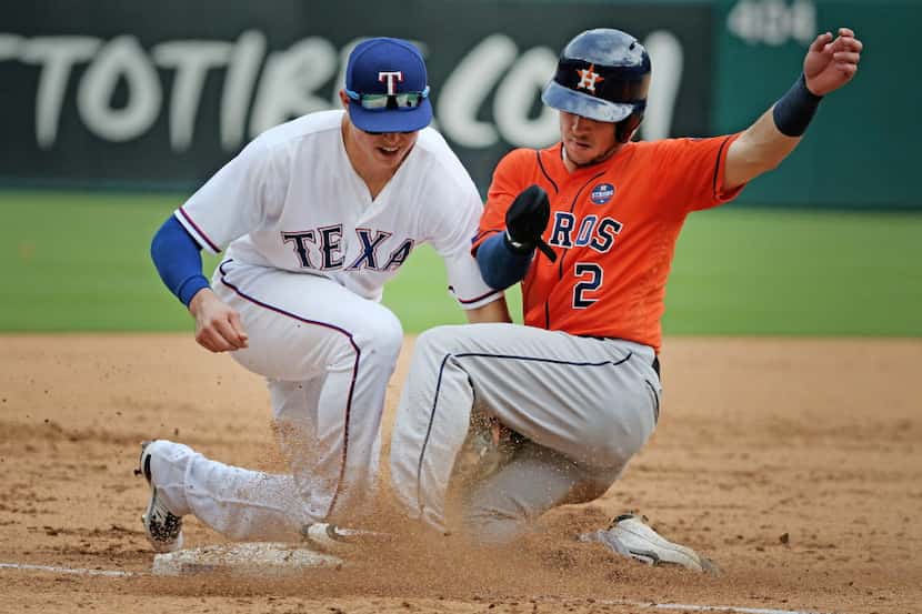 Houston Astros third baseman Alex Bregman (2) is tagged out at third base as Texas Rangers...