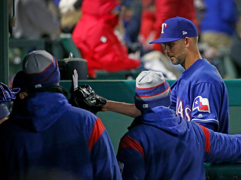 Texas Rangers starting pitcher Mike Minor, right, walks to the dugout after giving up one...