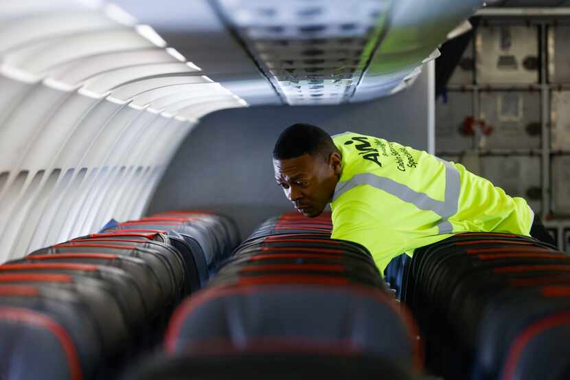 Cleaning workers work on an American Airlines flight from Grand Rapids, MI on Tuesday, May...
