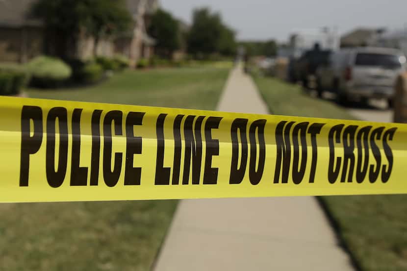 Crime scene tape marks off an area law enforcement investigators were working outside the...
