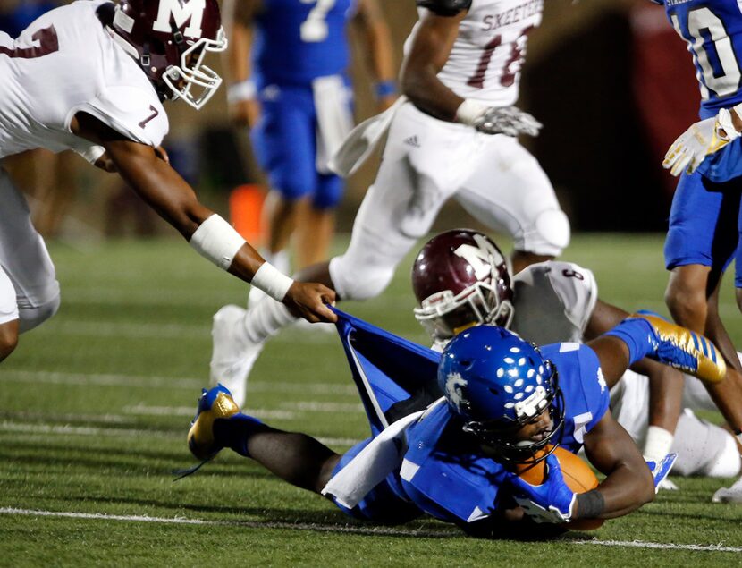 Mesquite defender Alex Vigil (7) drags down North Mesquite RB Tylon Sanders (4) during first...