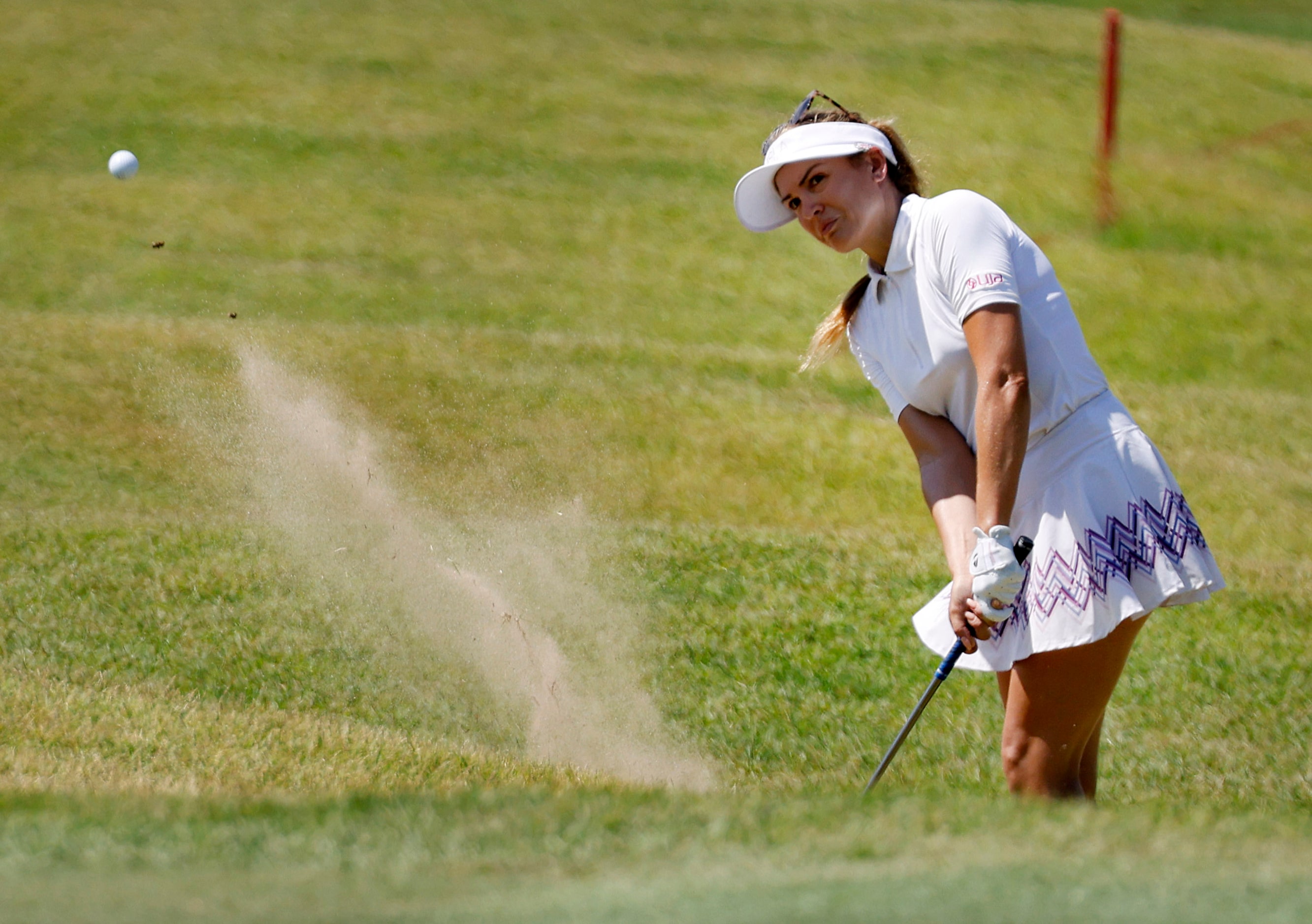 Professional golfer Sydnee Michaels fires a shot out of the sand on No. 17 during the...