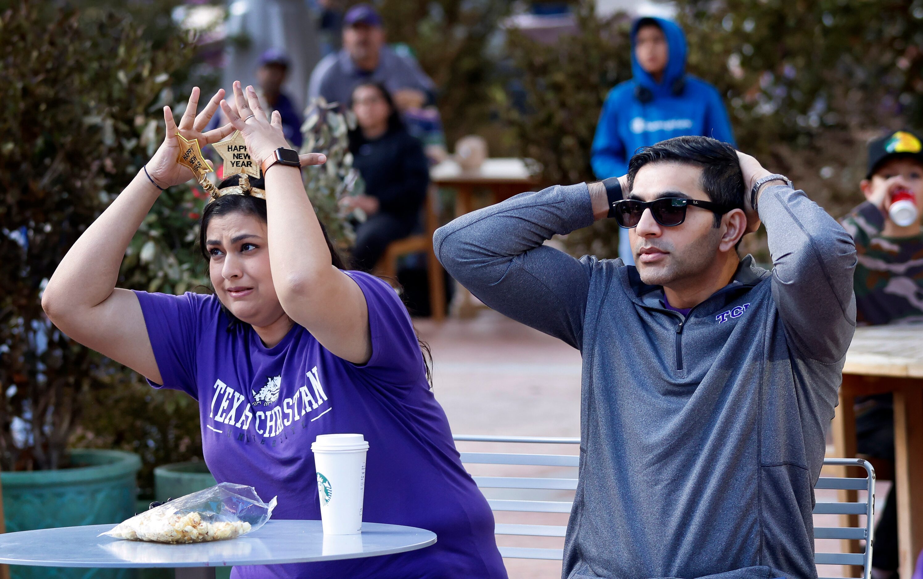 TCU Horned Frogs alums Wardah Iqbal (left) and her husband Azeem Iqbal react to a play...