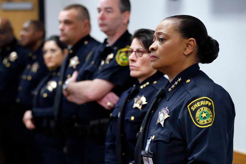 Alongside her deputies, Dallas County Sheriff Marian Brown listens during a press...