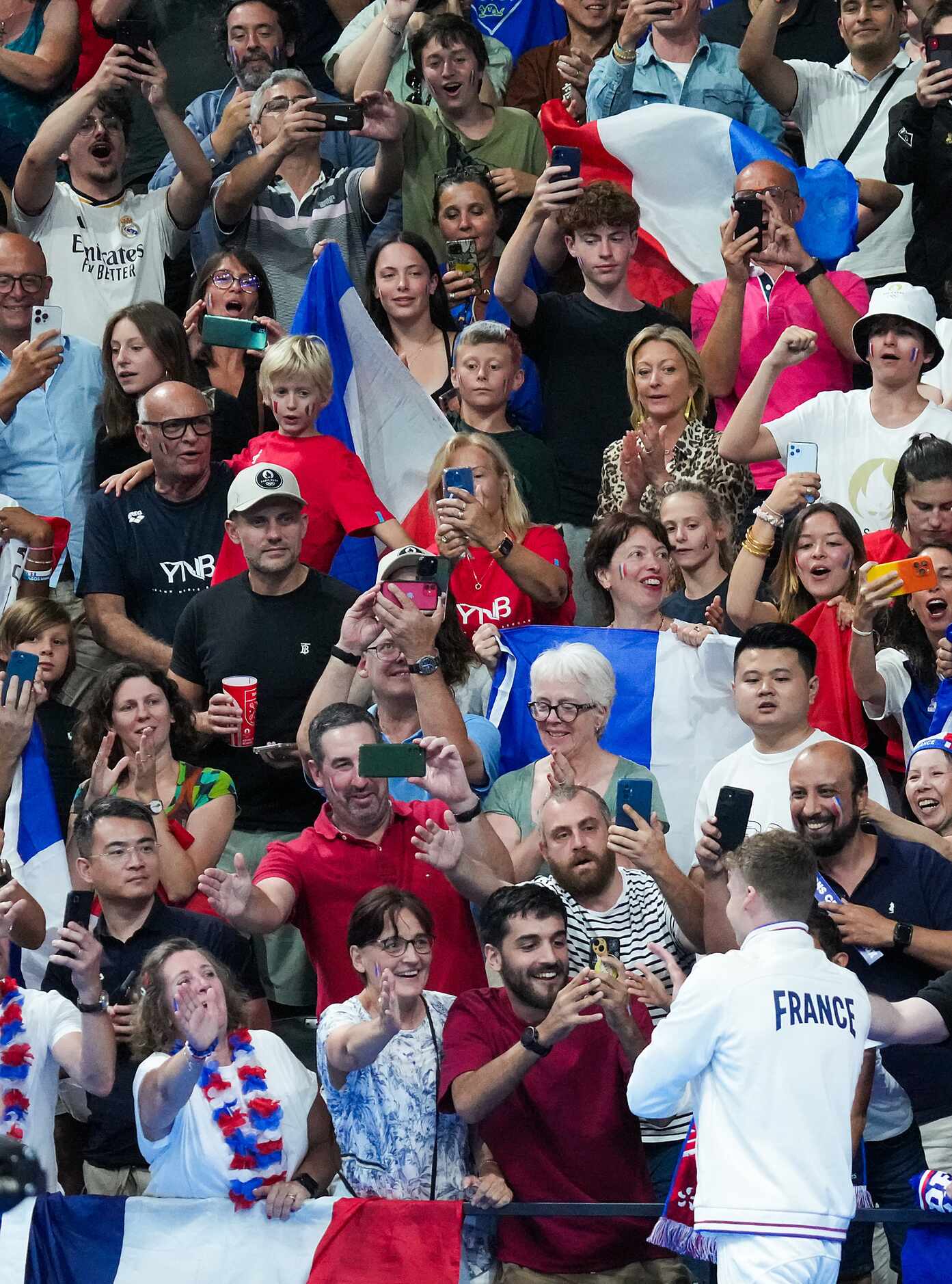 Leon Marchand of France celebrates with fans after winning the men's 400-meter individual...