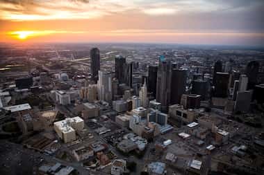 The sun sets behind the Downtown Dallas skyline last March.