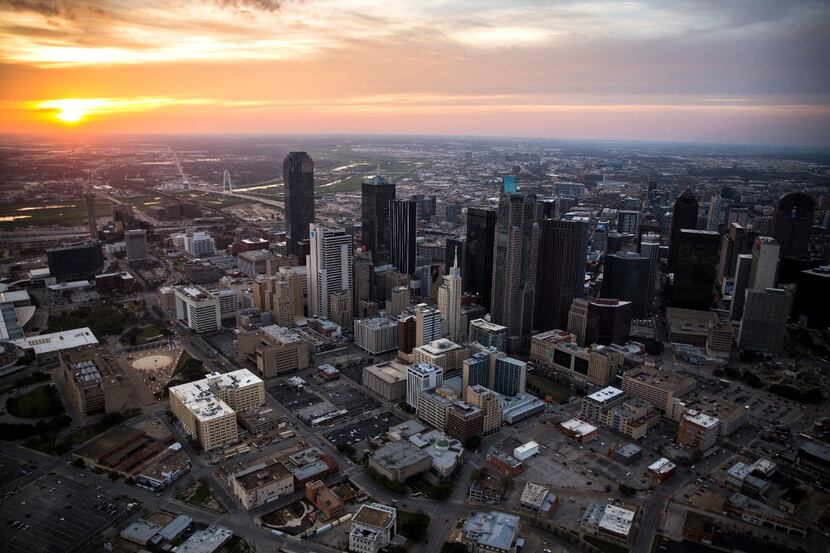 The sun sets behind the Downtown Dallas skyline last March.
