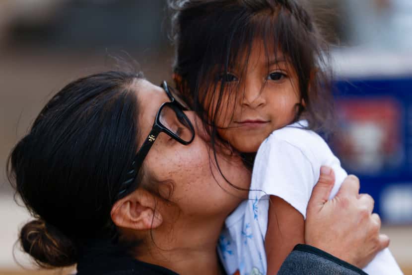 La Tiendita volunteer Gabrielle Castro kisses her daughter, Celeste, 5, after she comes by...
