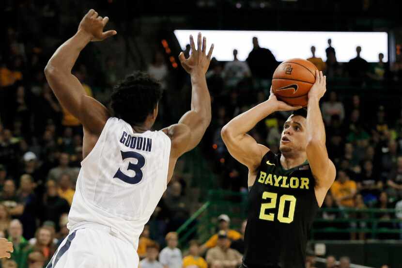 Xavier guard Quentin Goodin (3) leaps forward while defending against Baylor guard Manu...