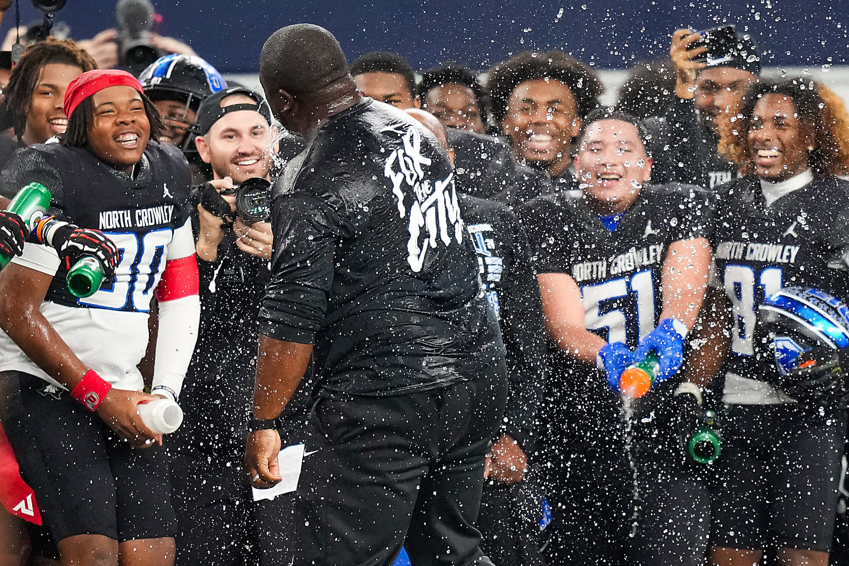 North Crowley head coach Ray Gates is doused by his players, including Boone Harris (30),...