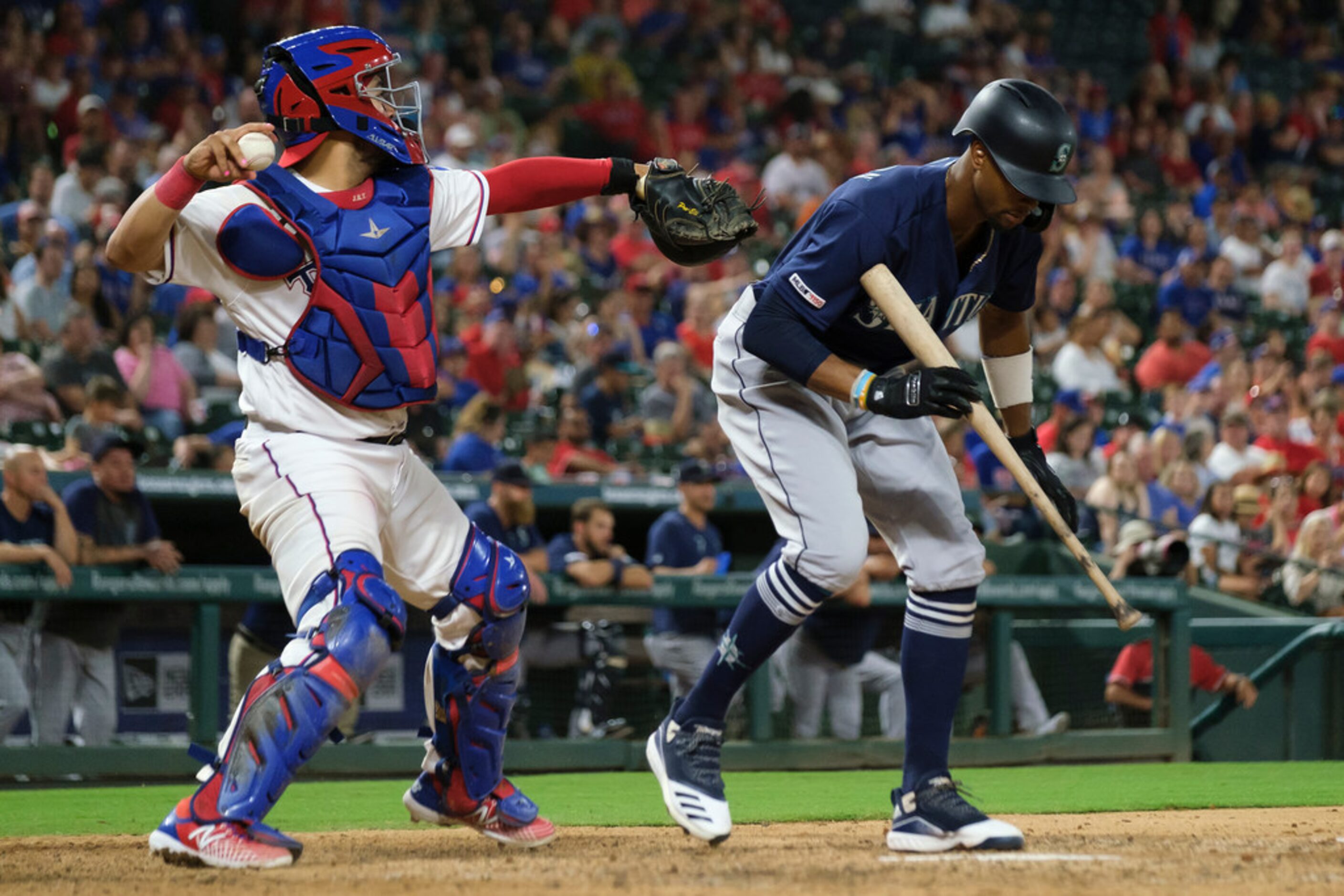 Texas Rangers catcher Jose Trevino makes a throw over Seattle Mariners center fielder Keon...