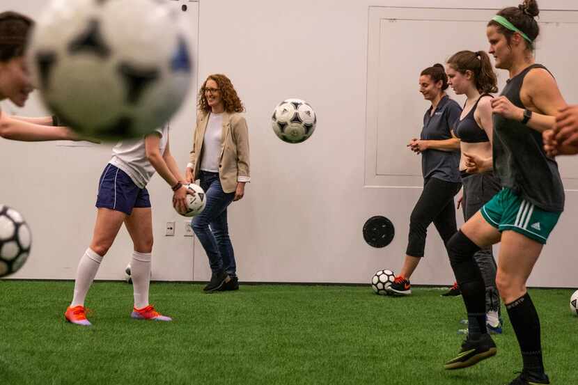 Director Wendy Dann walks by as the cast practices their soccer skills during a rehearsal...