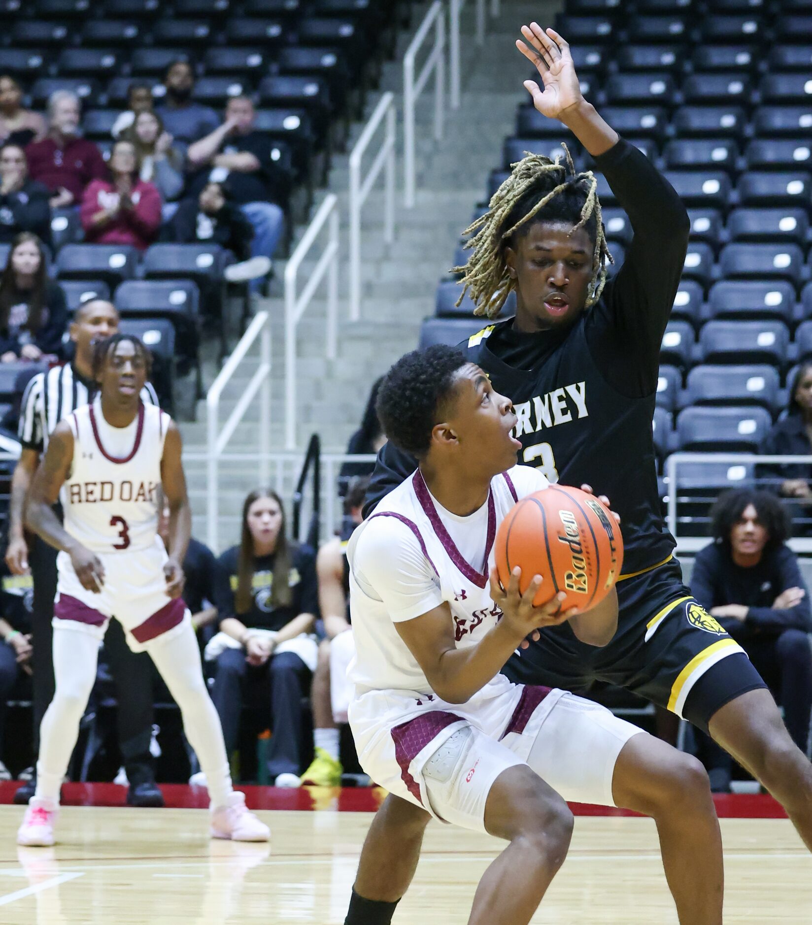 Red Oak freshman guard Michael Gatewood (11, left) is stopped in his tracks by defending...