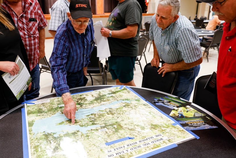 Longtime Cuthand, TX resident Gary Cheatwood, center left, points to the outskirts of the...