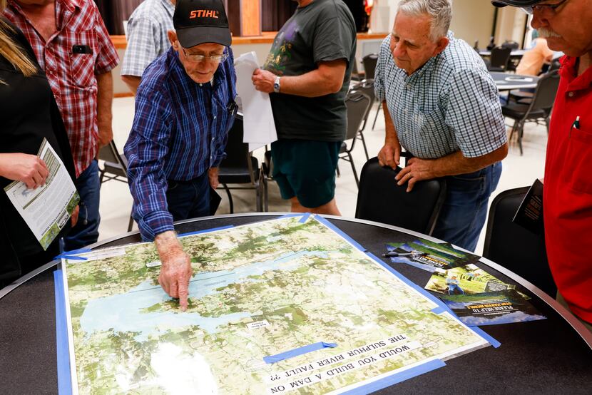 Longtime Cuthand, TX resident Gary Cheatwood, center left, points to the outskirts of the...